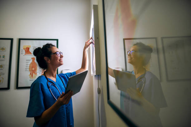 istock Side view of smiling middle aged nurse checking X-ray in a doctors office. 920956910