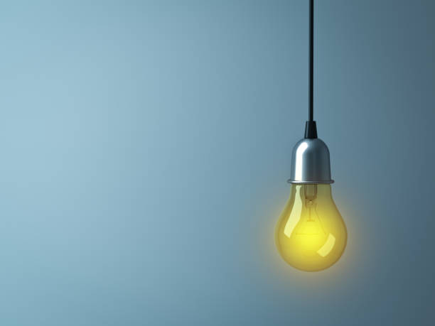 istock Hanging Light bulb glowing on dark cyan background 920957116