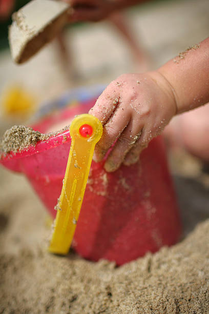 Dziewczyna wprowadzenie piasek do wiadra na plaży – zdjęcie