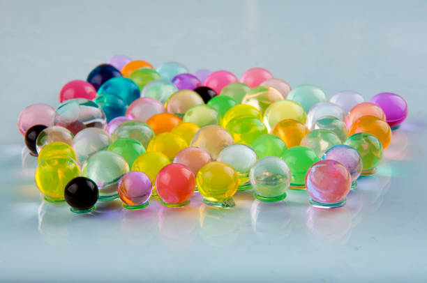 istock Orbeez balls lay on glass surface on white background. Front view 920974954
