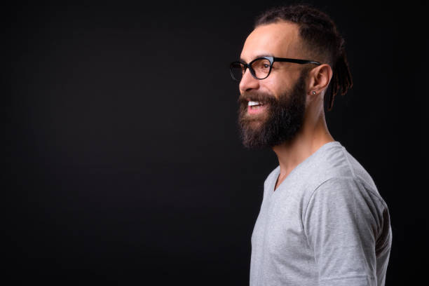 Handsome Young Man Against Black Background Studio Shot Of Handsome Young Man Against Black Background horn rimmed glasses stock pictures, royalty-free photos & images