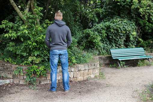 Rear View Of A Man Peeing In Park