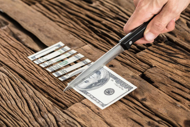 istock Hand Cutting The 100 Dollar Bill With Knife 920982032