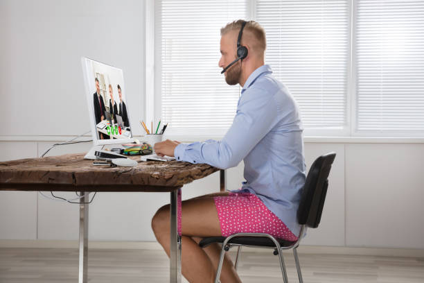 Businessman Attending Video Conference On Computer Businessman Dressed In Shirt And Shorts Having Video Call On Computer In The Home Office shorts stock pictures, royalty-free photos & images