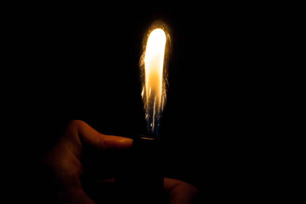 istock Close up view of real sparking light from lighter in dark black background 920993198