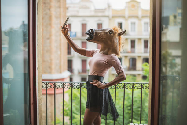 paard masker vrouw selfie op een balkon - gekke paarden stockfoto's en -beelden