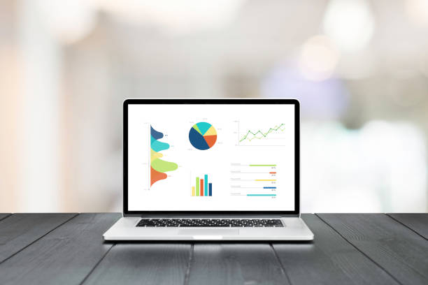 istock Laptop on wooden table showing charts and graph 920998196