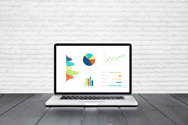 istock Laptop on wooden table showing charts and graph 920998214