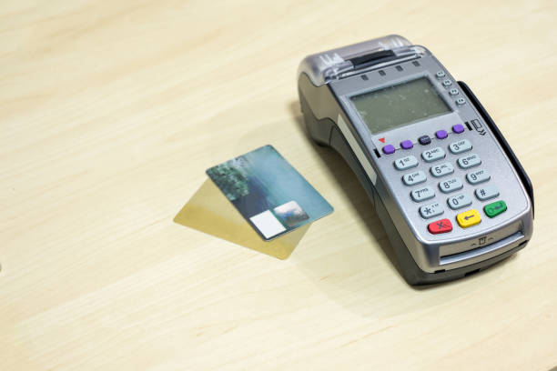 carte de crédit avec terminal sur bois bureau de paiement - gold paying internet credit card photos et images de collection