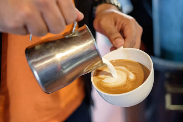 バリスタが心を作るコーヒー カップに牛乳を注いで - barista coffee coffee crop heart shape ストッ�クフォトと画像