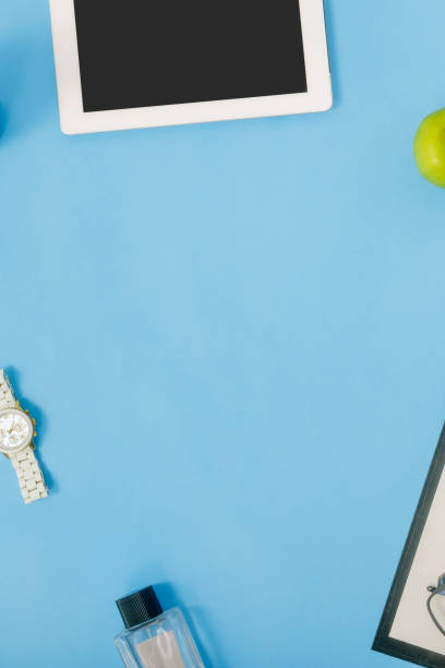 istock Office desk workspace. Frame from tablet, wrist watch, female perfume, clipboard and apple. Flat lay, top view 921013340