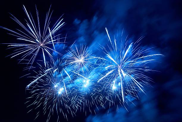 White fireworks on a black and blue background stock photo