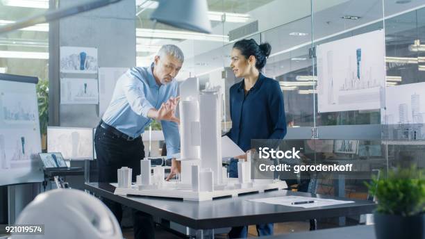 Chief Male Architect And Female Engineer Work With City Buildings Model Bright People Work As Urban Planners Stock Photo - Download Image Now