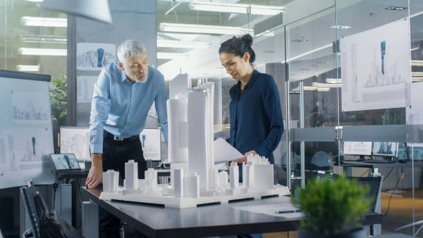 istock In the Architectural Bureau Two Engineers Work on a Model of a City District. Urban Planners Work on a Functional Building Model. 921019578