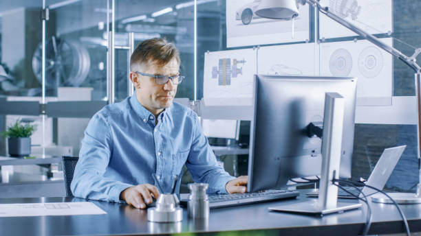 istock Experienced Industrial Engineer Working on Personal Computer in the Stylish, Modern, Glass Office. 921019588