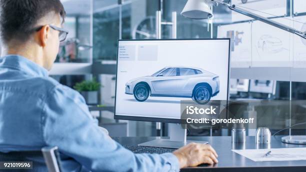 Automotive Engineer Works On The Personal Computer He Perfects New Car Model Prototype Sketch He Works In The Bright And Modern Office Stock Photo - Download Image Now