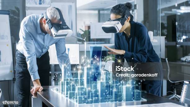 Männliche Und Weibliche Architekten Tragen Augmented Reality Headsets Arbeit Mit 3d Stadtmodell High Tech Büro Professionelle Leute Verwenden Virtual Reality Modeling Softwareanwendung Stockfoto und mehr Bilder von Virtual-Reality-Simulator