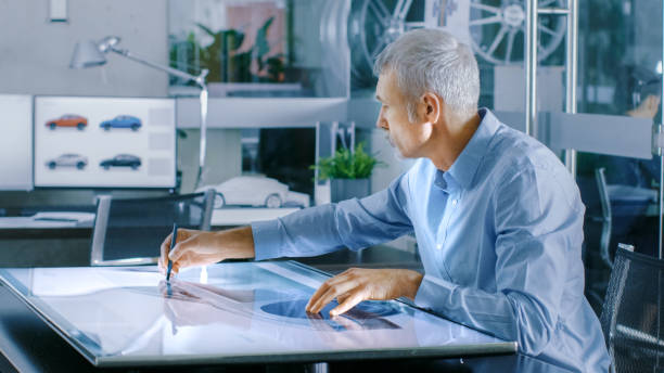 istock Experienced Automotive Designer Works With Digital Display Graphics Tablet Touschreen Table, Drawing Sketch of a New Car Prototype. 921019790
