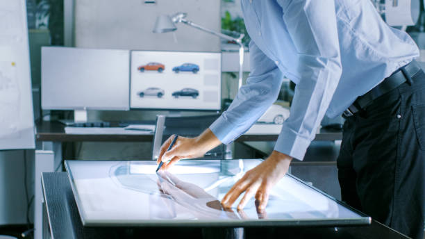 istock Experienced Automotive Designer Works With Digital Display Graphics Tablet Touschreen Table, Drawing Sketch of a New Car Prototype. 921019792