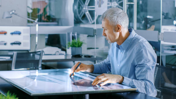 istock Experienced Automotive Designer Works With Digital Display Graphics Tablet Touschreen Table, Drawing Sketch of a New Car Prototype. 921019796
