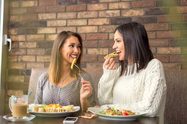 istock Two girlfriends having lunch together at a restaurant 921020202