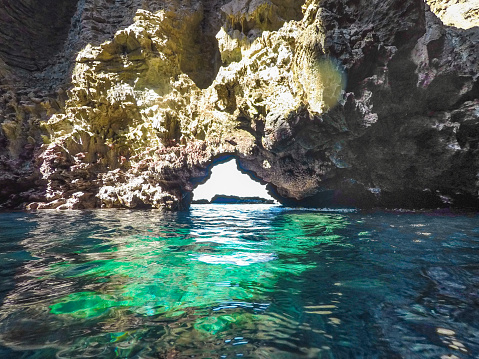 The Krabi region of Thailand is dotted with hundreds of limestone Karst islands.  Many have been eroded from within and contain secret caves such as this one.  Many can only be accessed at low tide.  Image taken whilst snorkelling at Ko Haa, Andaman Sea, Thailand.