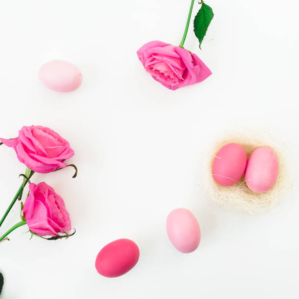 istock Easter egg and quail eggs in nest and pink roses on white background. Top view, Fat lay. Easter holidays 921028948