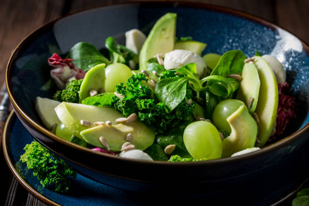 istock Kale salad with avocado, lettuce and grape in blue bowl 921029728