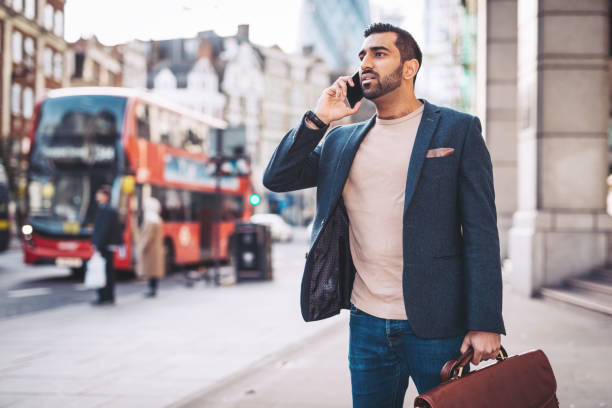 istock Indian lawyer with briefcase using phone to talk to the assistant 921032262