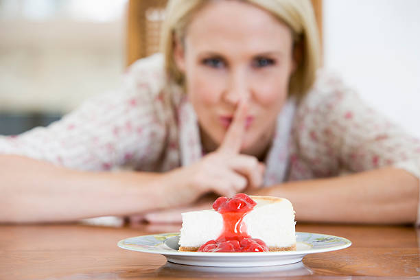 donna con una fetta di torta di ricotta alla fragola - avere la bocca cucita foto e immagini stock