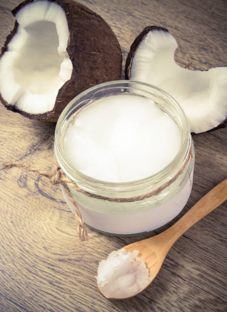 istock Coconut oil and fresh coconuts on a wooden table. 921040418