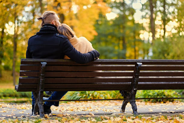 istock Rear view of couple sits on a bench. 921042124