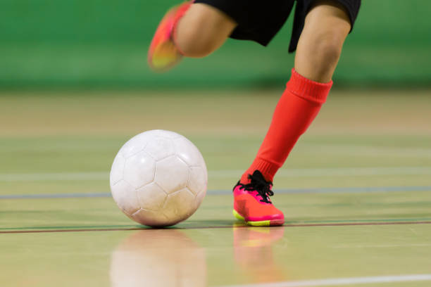 allenamento di calcio a 5 per bambini. giovane giocatore di calcio indoor con un pallone da calcio in un palazzetto dello sport. background sportivo. - futsal indoors soccer ball soccer foto e immagini stock