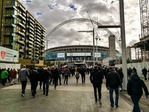 London, UK - October 22, 2018: supporters of Tottenham Hotspur FC walking on Wembley Way outside Wembley Stadium before a match in the Premier League, the top division in English football. Room for copy space.