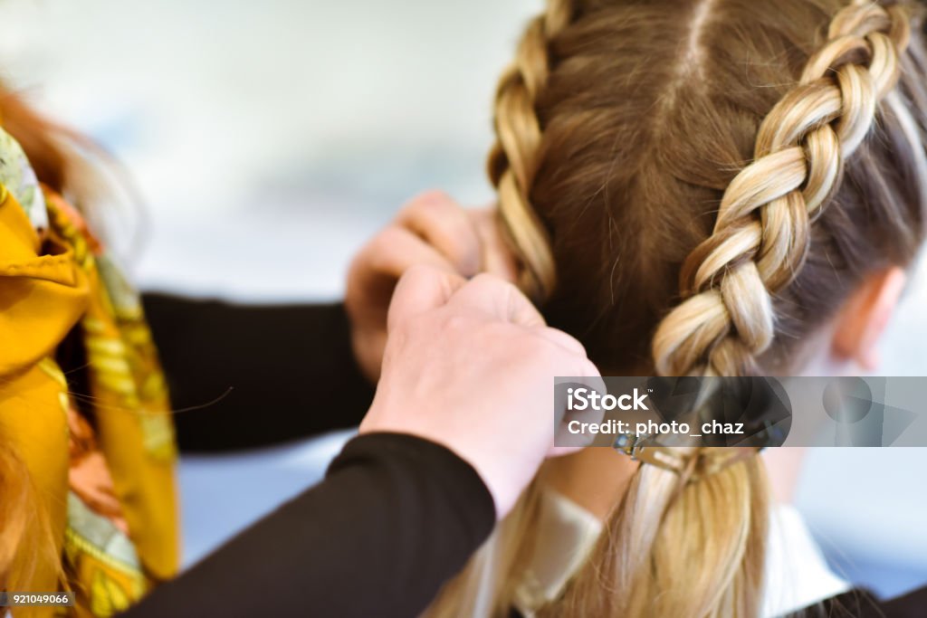 Braided Hair A women getting her hair done in braids by a stylist Braided Hair Stock Photo