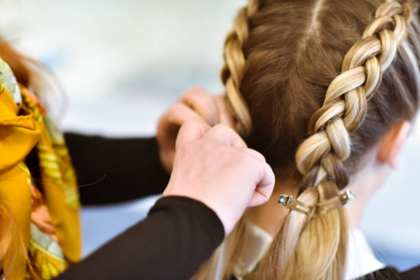 Braided Hair A women getting her hair done in braids by a stylist braided hair stock pictures, royalty-free photos & images