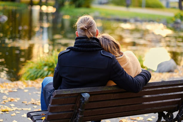 istock Rear view of couple sits on a bench. 921051826