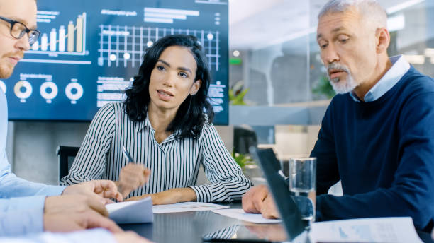 istock Group of Smart and Respectable Business People Work on a Problem Solving in the Meeting Room. Diverse Group of Mixed Ethnicity and Gender Explore Potential for Company Future Development. 921054652