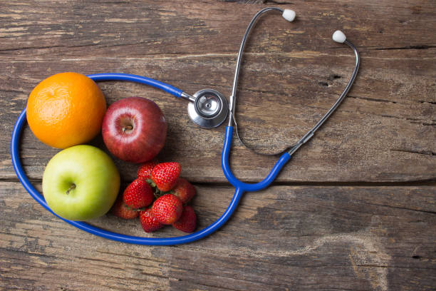 istock Stethoscope and fruits on wood 921058290