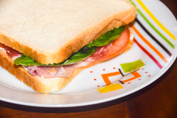 istock sandwich with prosciutto tomato and green salad on  bright plate 921058488