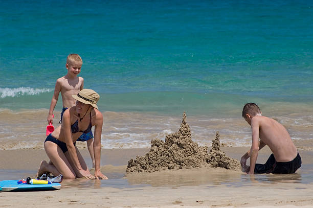 istock Happy family building sand castles on the beach 92105943