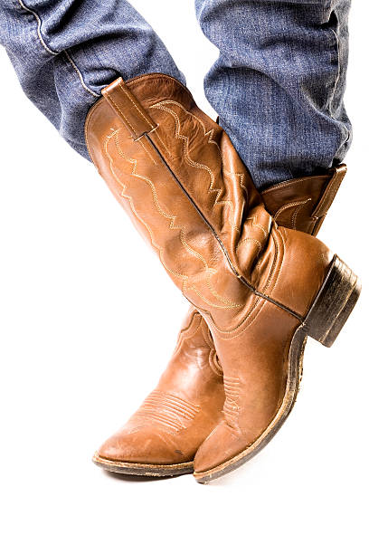 Close-up of feet in cowboy boots and jeans stock photo