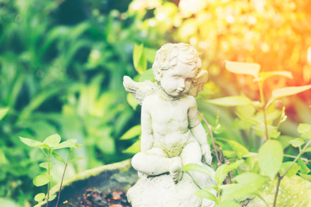 istock white Cupid sculpture in the garden with light effect 921064142