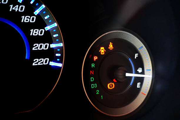 detail with the fuel gauges showing and empty tank on dashboard - half tank imagens e fotografias de stock
