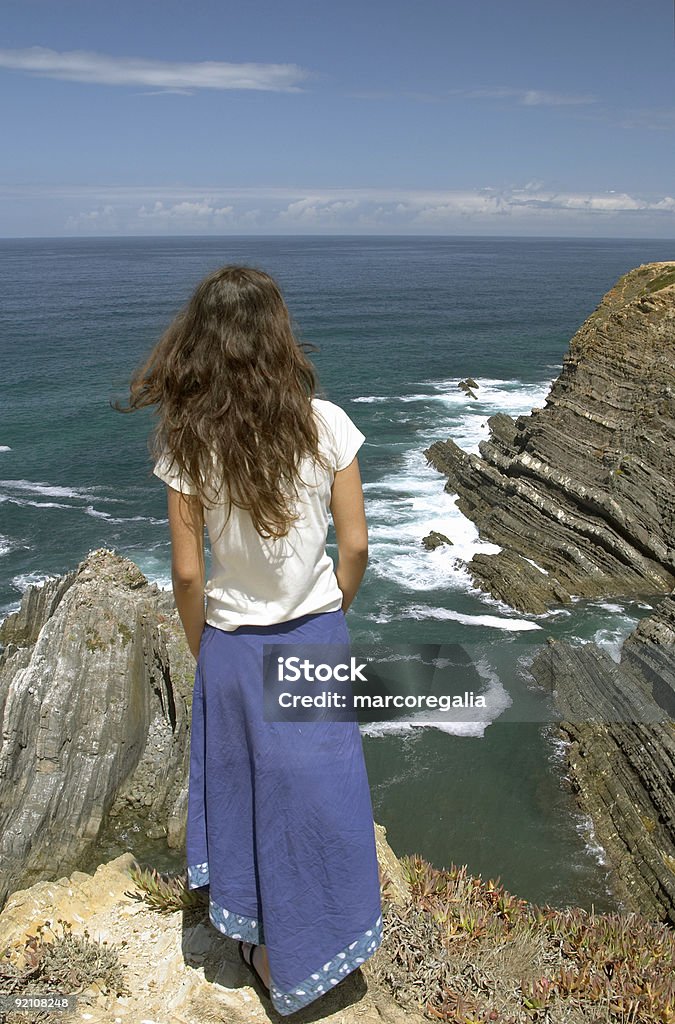 Молодой Каштановые длинные волосы женщины европеоидной расы с синей юбкой, стоя - Стоковые фото Вертикальный роялти-фри