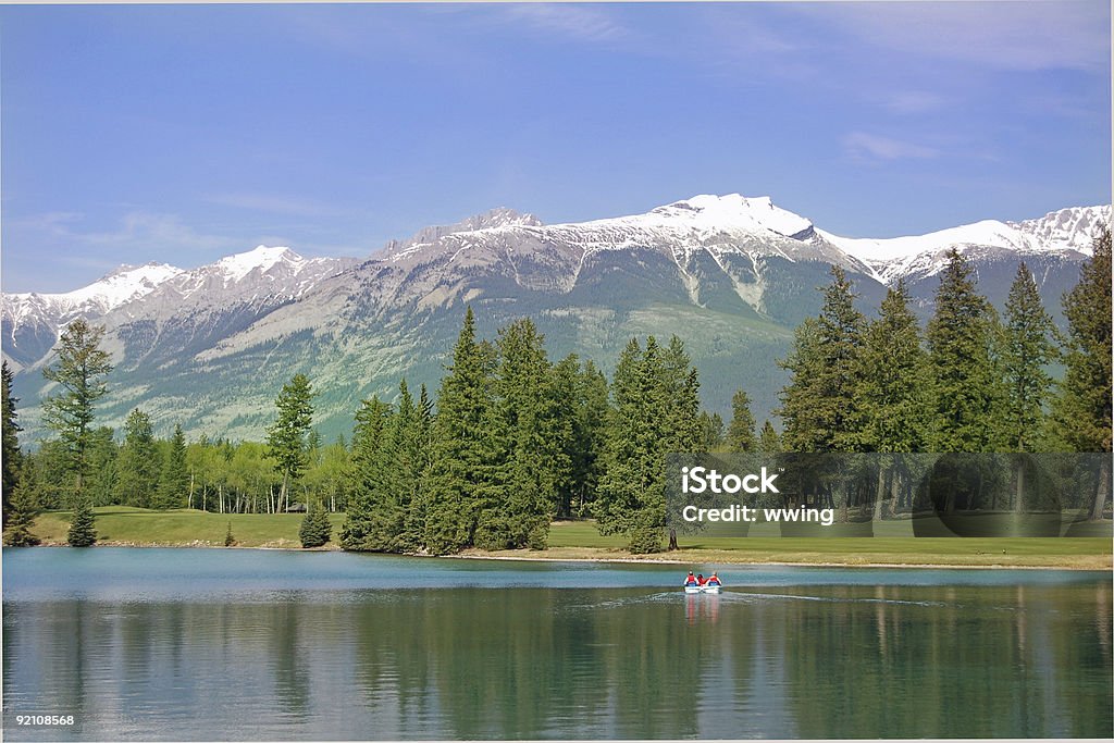 Boaters on Mountain Lake with Dramatic Surroundings Paddle boaters on Pristene Lake in Jasper National Park at Jasper Park Lodge Color Image Stock Photo