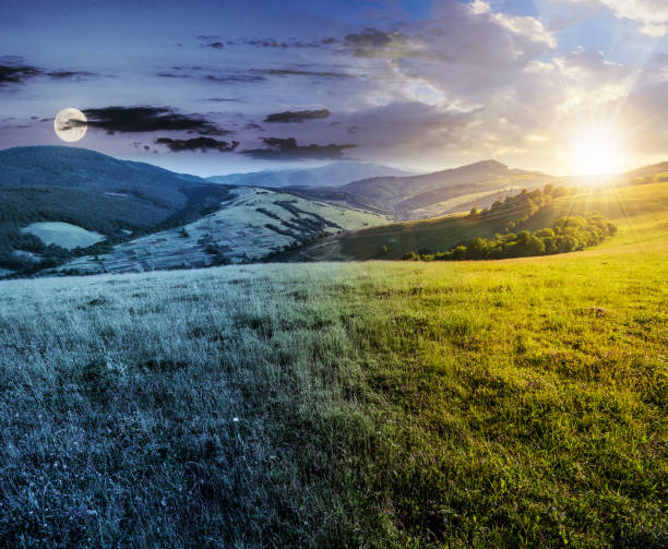time changes over grassy meadow in mountains stock photo