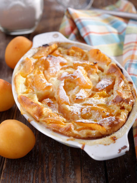 Apricot clafoutis Apricot clafoutis in a baking dish on a rustic table clafoutis stock pictures, royalty-free photos & images