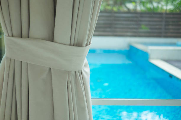 istock Curtain drapery interior home decoration on window with swimming pool background 921092136