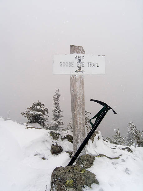 Winter Mountain Peak trail sign with ice axe stock photo